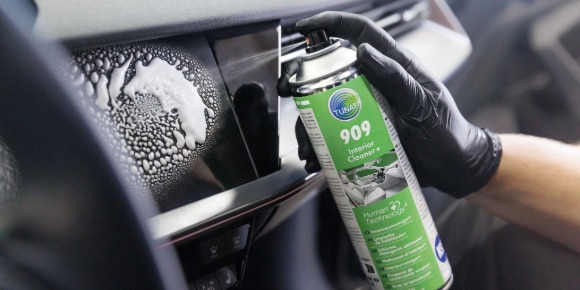 Hand putzt Scheibe am Auto mit TUNAP Reiniger