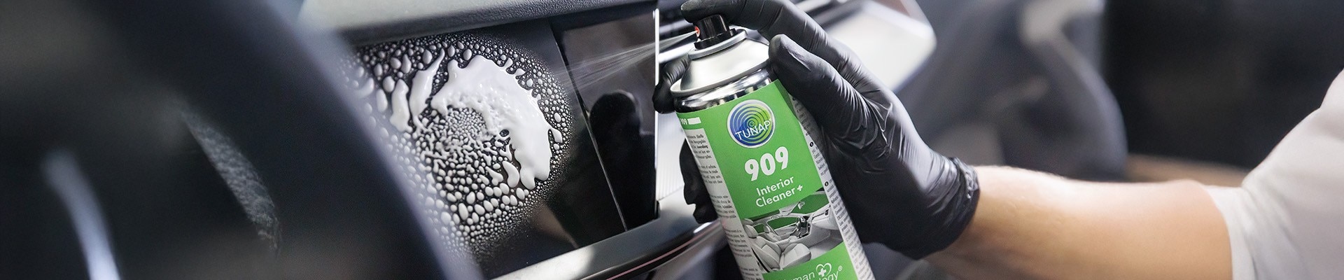 Hand putzt Scheibe am Auto mit TUNAP Reiniger